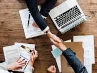 Auditor and client shaking hands over signed certification paperwork